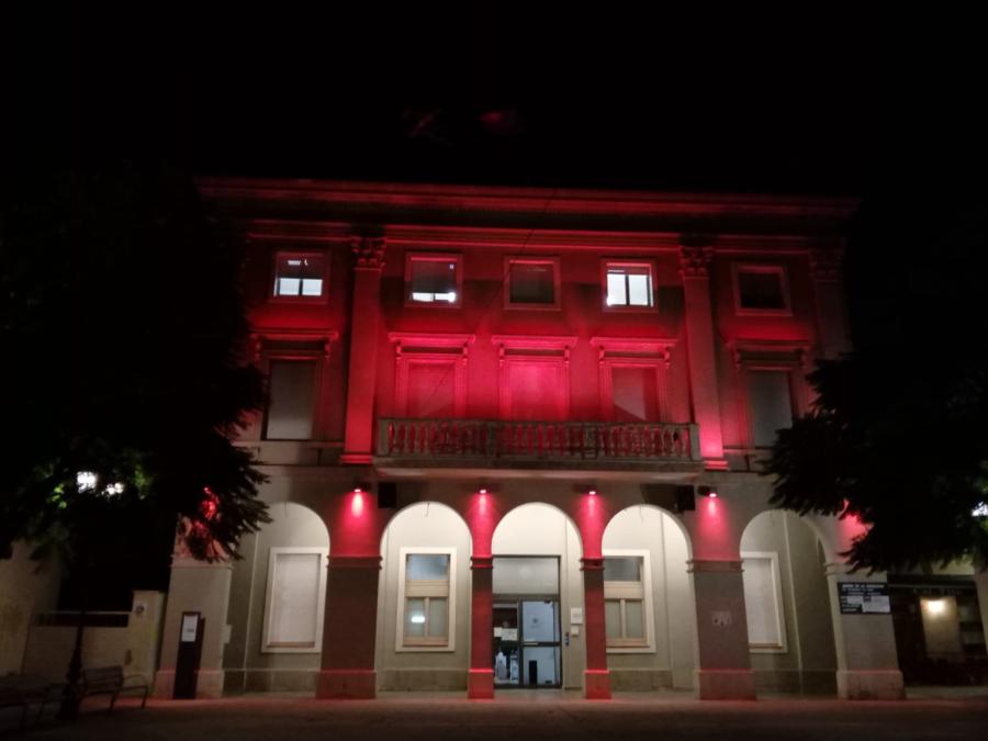 Façana de l'Ajuntament il·luminada de color vermell